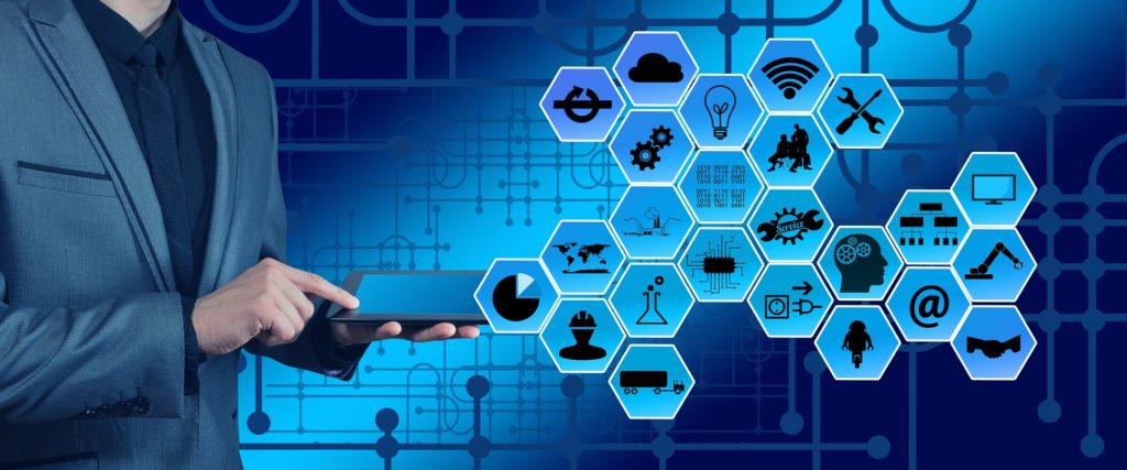 homme en costume utilisant une tablette avec icônes d'infogérance et services informatiques en hexagones bleus