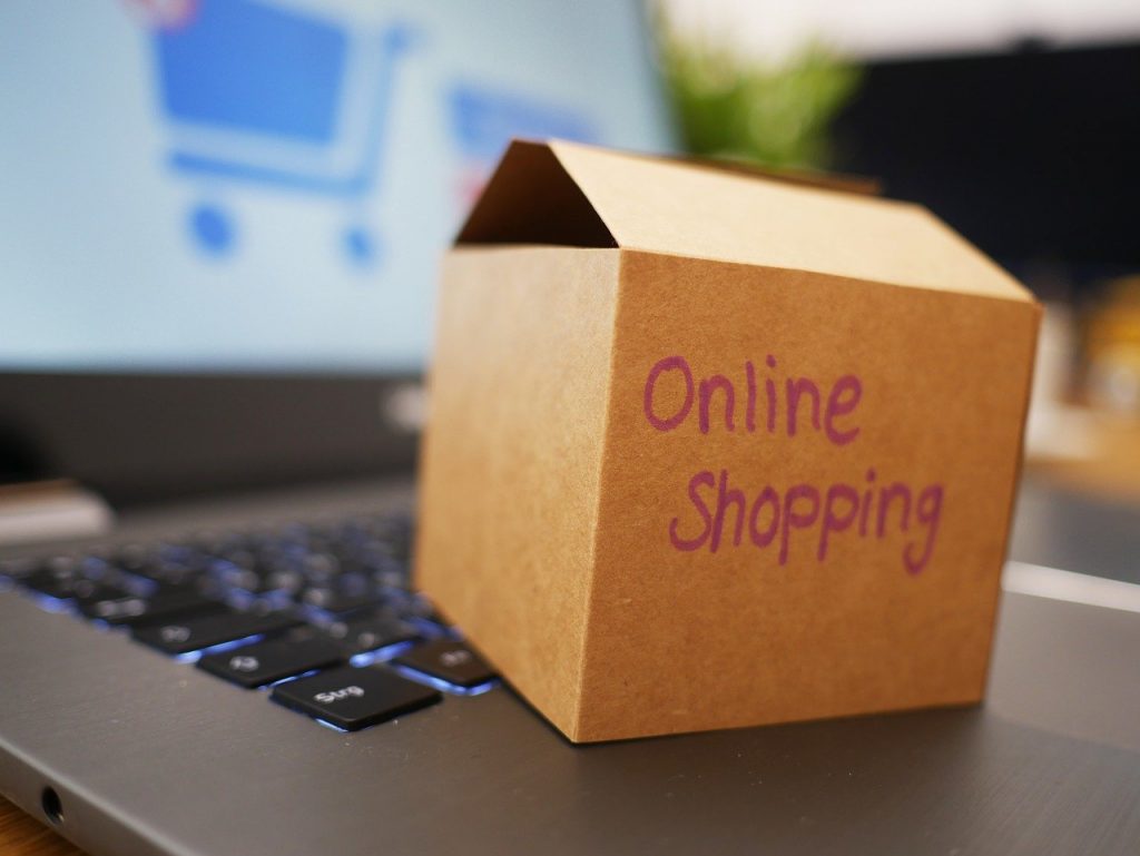 boîte en carton avec "online shopping" écrit dessus posée sur un clavier d'ordinateur