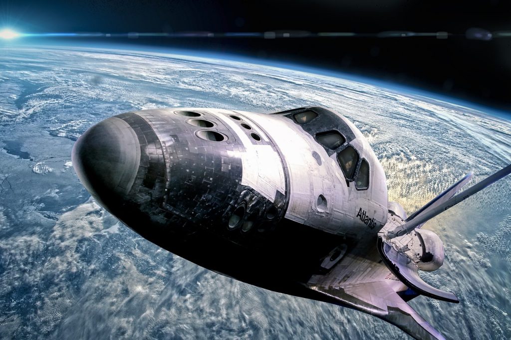 navette spatiale atlantis en orbite au-dessus de la terre avec nuages et atmosphère bleue