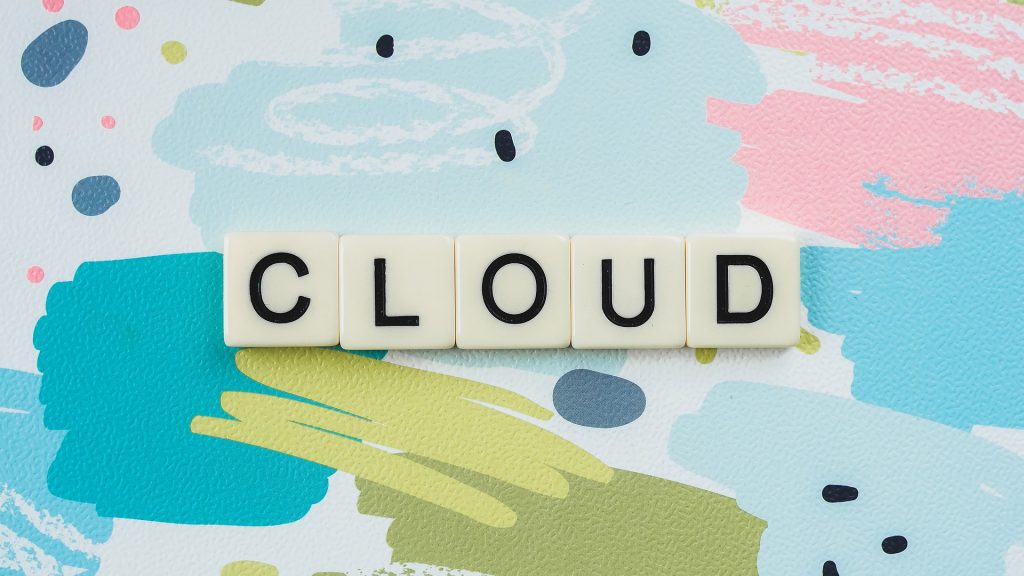le mot "cloud" écrit sur des carrés blancs sur un fond coloré avec des formes géométriques