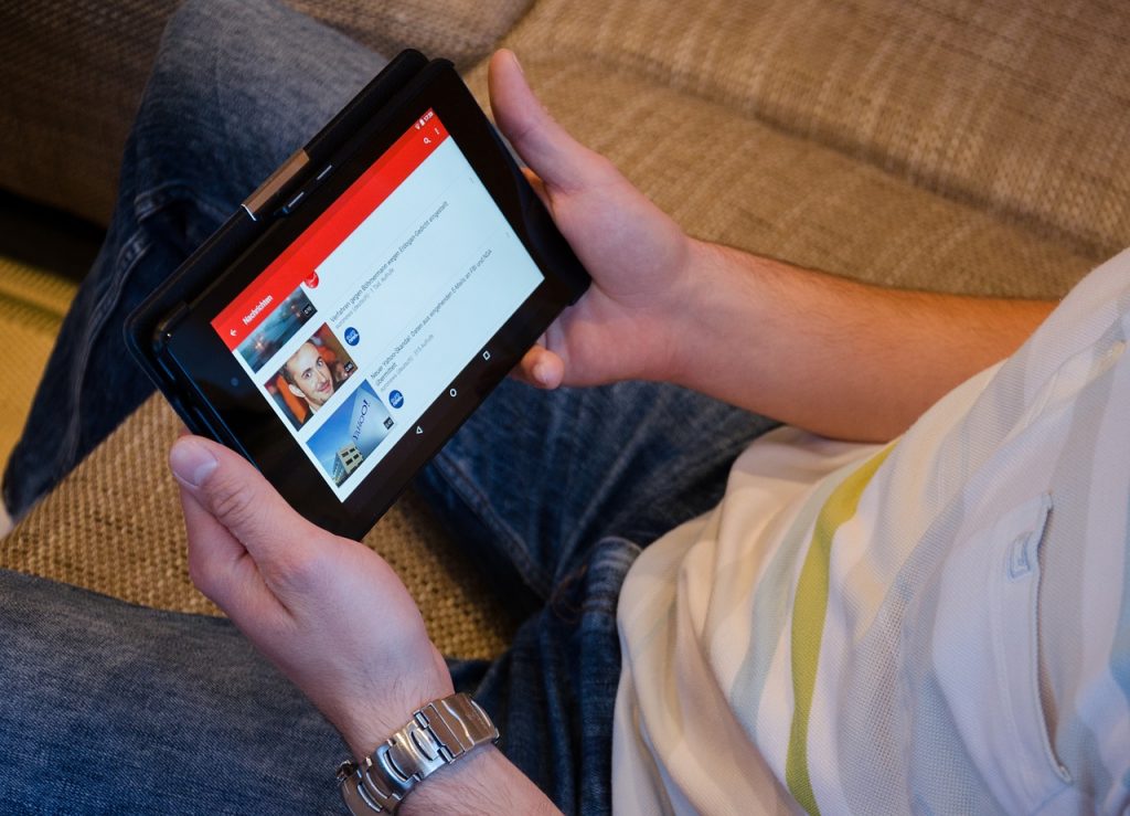 personne tenant un smartphone affichant l'interface de youtube en mode incognito