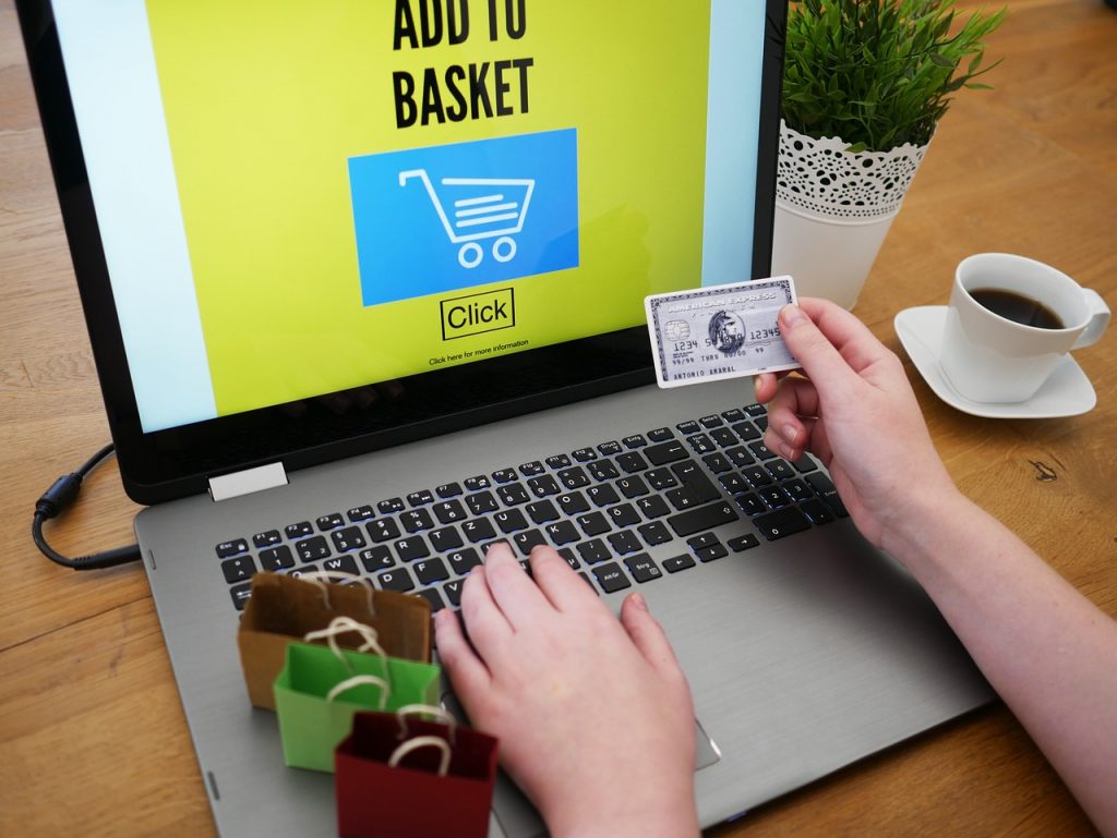 personne effectuant un achat en ligne avec carte bancaire sur un ordinateur portable