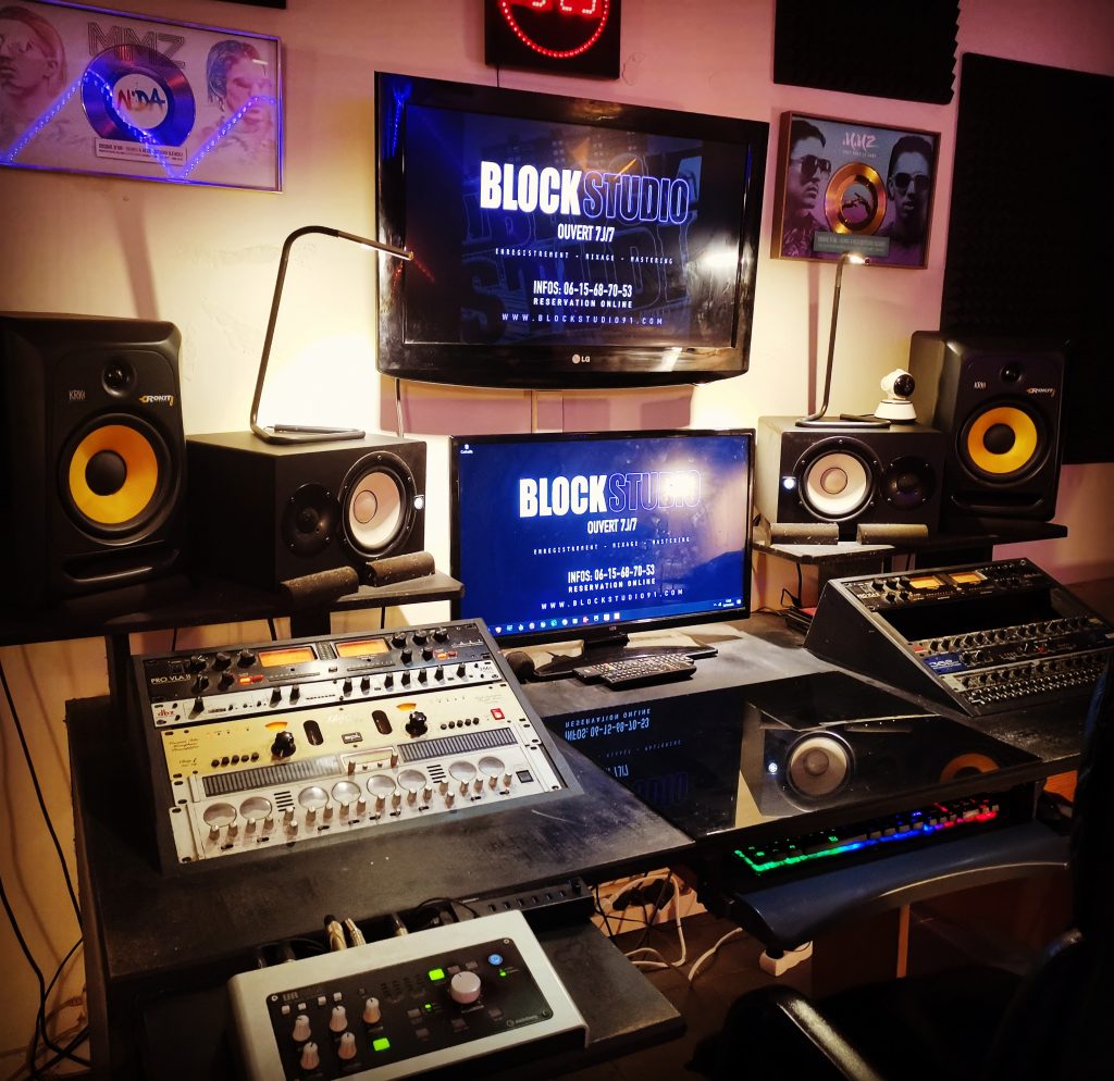 studio d'enregistrement professionnel avec synthétiseurs, contrôleurs midi et moniteurs de studio