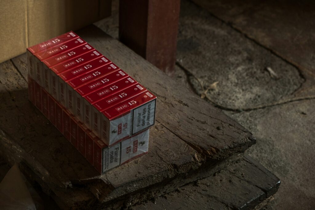 paquet de cigarettes rouges reig empilés sur un sol en béton