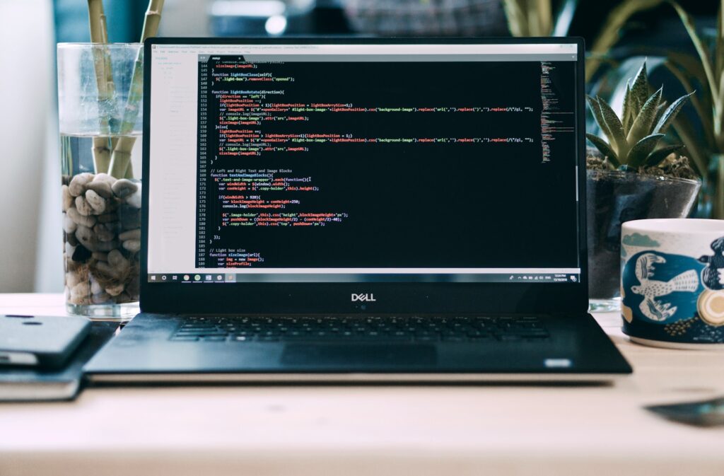 écran de laptop affichant du code de programmation CNC sur un bureau avec plantes