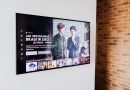 Smart TV displaying streaming content in modern living room setting with exposed brick wall.