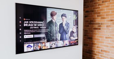 Smart TV displaying streaming content in modern living room setting with exposed brick wall.
