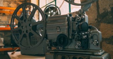 Close-up of a vintage film projector in a rustic, dimly lit room with stone walls.