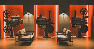 A cozy retro cinema room showcasing vintage film projectors and comfortable seating.