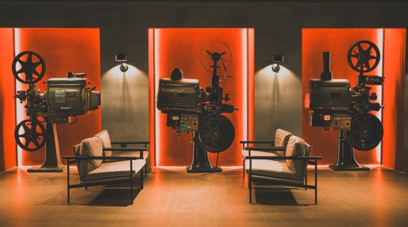 A cozy retro cinema room showcasing vintage film projectors and comfortable seating.