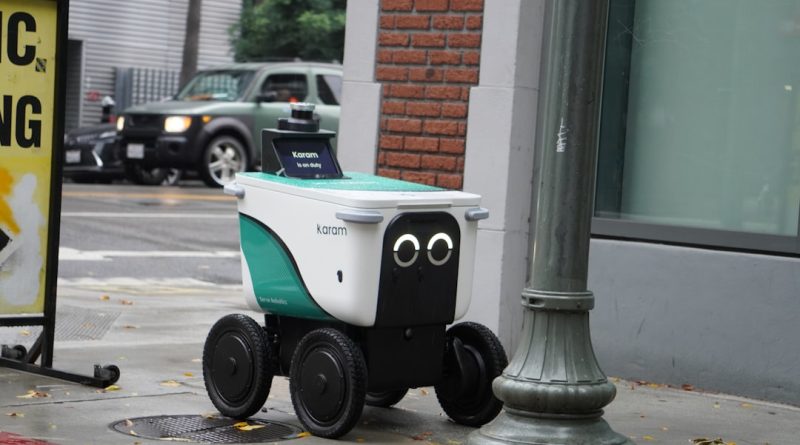A small delivery robot with googly eyes on a sidewalk